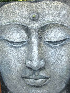 visage de Bouddha sur fond sablé gris