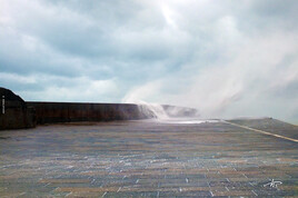 Vague débordant sur la digue